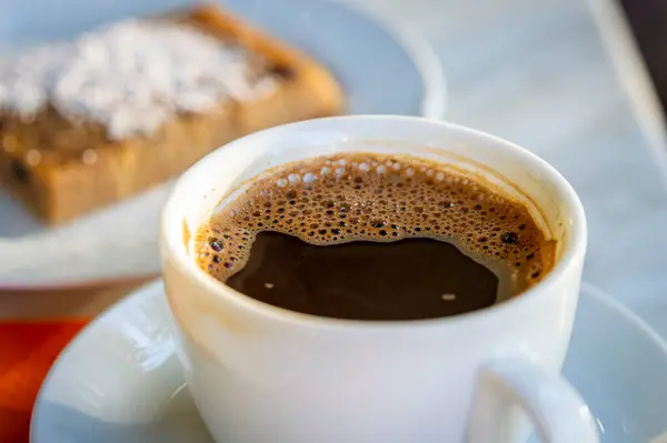 Yunan kahvesi yemek masasına konmuş ve arka planda Yunan pastası bulanıklaşmış