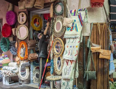 Marakeş, Fas, 8 Nisan 2023. Marakeş Medine 'de malları hazırlayan bir erkek dükkan sahibi güneşli bir günde alışveriş yapar..