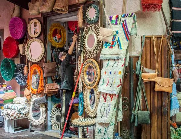 Marakeş, Fas, 8 Nisan 2023. Marakeş Medine 'de malları hazırlayan bir erkek dükkan sahibi güneşli bir günde alışveriş yapar..