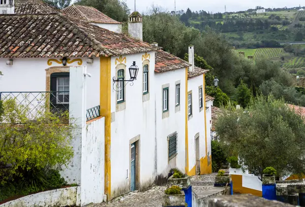 Ölüm ilanları, Portekiz, 8 Mart 2025. Tarihi Obidos kasabasındaki renkli eski Portekiz evleri manzarası.
