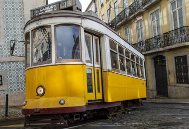 Lizbon, Portekiz, Mart 07, 2025. İkonik sarı Tramvay 28 Lizbon şehir merkezinin tarihi caddelerinde ilerliyor..  