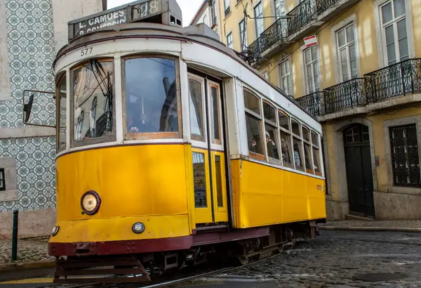 Lizbon, Portekiz, Mart 07, 2025. İkonik sarı Tramvay 28 Lizbon şehir merkezinin tarihi caddelerinde ilerliyor..  