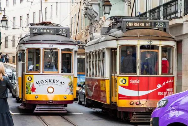 Lizbon, Portekiz, Mart 07, 2025. Lizbon şehir merkezinde tarihi bir stree içinde renkli bir Tram 28 manzarası.  