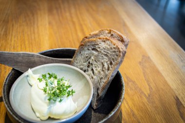 Norveç 'teki yerel bir restoranda yemek masasında tereyağlı iki dilim ekşi ekmek servis ediliyor.