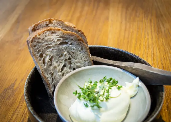 Norveç 'teki yerel bir restoranda yemek masasında tereyağlı iki dilim ekşi ekmek servis ediliyor.