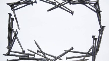 Gri üzerinde metal çiviler bulunan çelik ve vidalar.