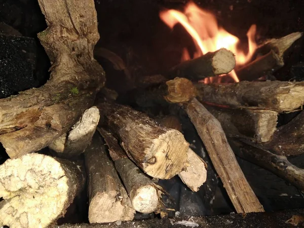 薪が燃え赤い炎の舌が木を覆い — ストック写真