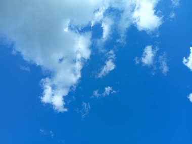 Hareketsiz hafif bulutların havada süzüldüğü sakin bir gökyüzü..