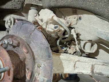 Araba tamiri. Araba arka süspansiyon bakımından geçiyor. Şasi sökülmüş..