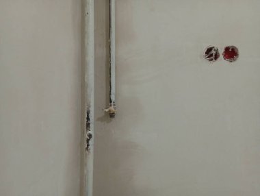 Mutfaktaki duvarları onarıyorum. Arka plandaki gaz boruları macunla işlenmiş..