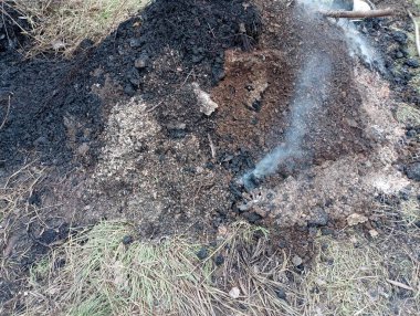 Sokakta duran bir odun külü yığını. Kazanın külleri hala sokakta yanıyor..