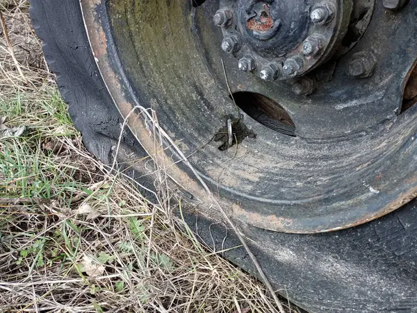 Damaged wheel of an old truck. Punctured and deflated car tires. An old tire with a puncture is installed on a car.