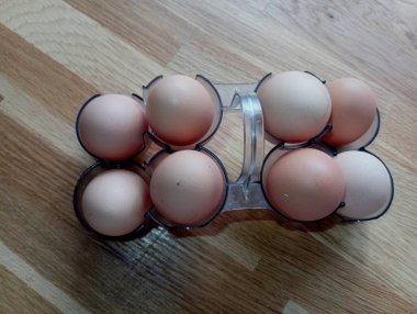 Ahşap masa zemininde yumurtaları olan plastik tepsi. Yemek ve lezzetli yemekler konusu.