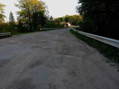 Derin çukurları olan kötü bir yol. Ulaşım konuları ve kötü yollar. Köyde asfalt yol kötü..