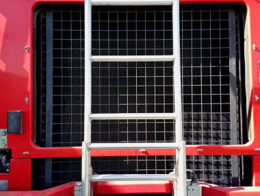 Önüne metal bir merdiven monte edilen özel bir itfaiye aracının soğutma radyatörü. İtfaiye aracının parçaları ve elementleri..