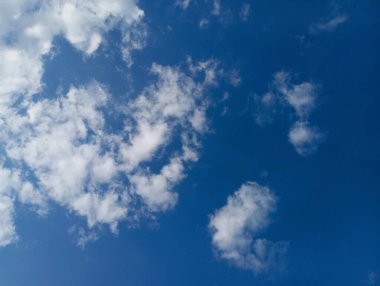 Küçük kabarık bulutlu mavi gökyüzü arkaplanı.