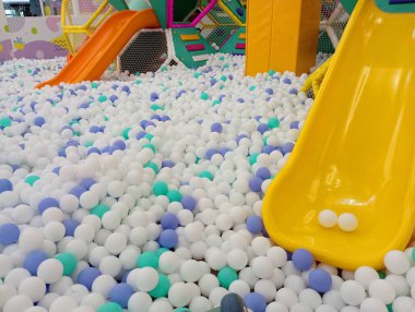 Havuz arka planı plastik toplarla dolu, slaytlarla ve çocuklar için eğlence. Çocuklar için Cazibe.