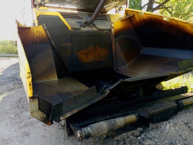 Asfalt kaldırımının özel bir bölümü sarı renktedir ve yol üzerine asfalt dökülür. Yol onarımı için kullanılan ekipman. Özel ekipman.