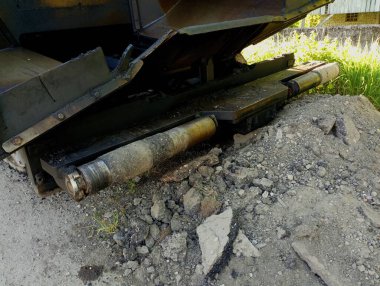 Yolun kenarına park edilmiş sarı bir kaldırım var. Yol onarımı ve yol yüzeyi restorasyonunun uygulanması için özel teknik araçlar.