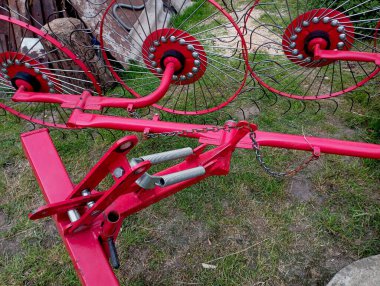 Kırmızı traktör saman tırmığı dışarıda. Samanı tırmıklamak için özel tırmık. Ekin biçmek için tarım ekipmanları.