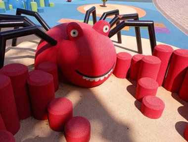 Çocuk parkındaki örümcek şeklinde çocuklar için büyük kırmızı bir cazibe. Gülümseyen büyük bir örümcek.