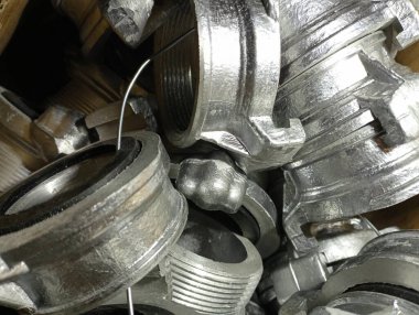 Metal geçiş başlarının dokusu yangın hortumları ve alüminyumdan yapılmış bağlantı başlıkları için. Yangın hortumlarını bir kutuya bağlamak için birkaç metal alüminyum başlık..