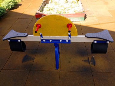 Çocuk parkında sarı-mavi salıncak. Çocuk salıncağı tam tersi. Eğlence temaları ve çocuklarla zaman geçirme.