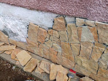 Dış duvarların ön cephelerini doğal kumtaşıyla tamamlamak. Onarım ve inşaat konuları.