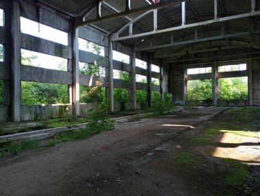 Yeşil ormanlarla kaplı terk edilmiş eski bir fabrikanın binası. Eski terk edilmiş sanayi tesisi.