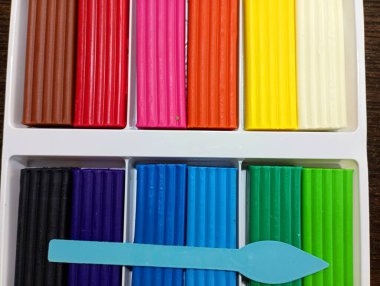 Rengarenk plastik parçalarla dolu bir kutu ve plastik bıçakla heykel yapmak için. Eğitim ve sanat konuları.