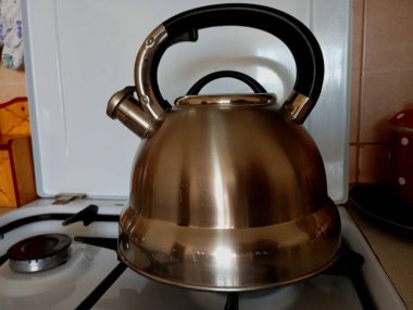 Gaz sobasının yüzeyindeki kaynar su için paslanmaz çelikten yapılmış metal bir çaydanlık. Sıcak içecek hazırlama konusu..