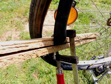 Bir bisikletin iç tüpünü klemp yardımıyla yapıştırma işlemi. Bisiklet tekerleği tamiri tam motorun üstünde..