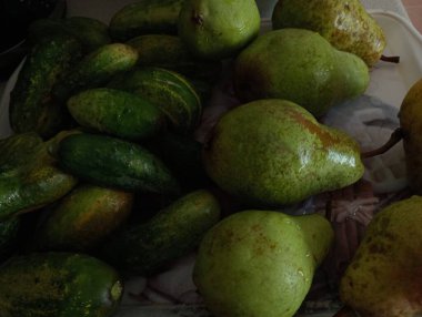 Tepside yıkanmış yeşil salatalıklar ve yeşil armutlar. Bahçemizin meyveleri ve sebzeleri.