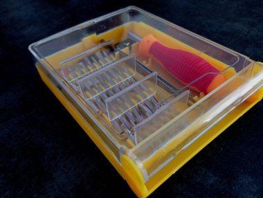 Küçük ev aletlerini şeffaf kapaklı sarı plastik bir çantada tamir etmek için bir dizi mini tornavida..