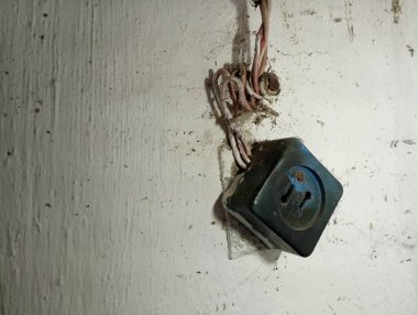 Eski bir duvardaki eski siyah elektrik prizi. Kablolama acil bir durumda. Elektrik ve elektrik akımı.