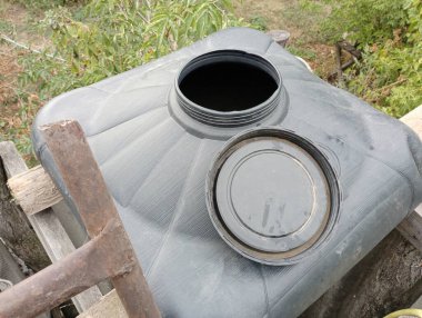 Büyük, kare bir plastik kap. Büyük boyunlu, siyah bir duş için. Yaz duşu düzenleme konusu..