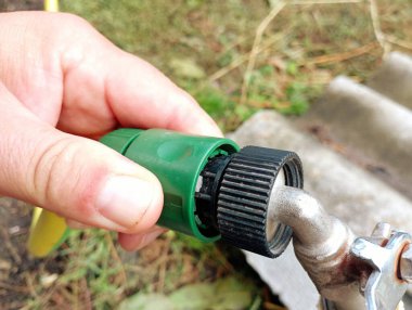 Özel bir plastik bağlantı kullanarak su hortumunu musluğa bağlama işlemi.