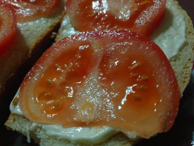 Ekmek üzerine mayonez dilimlenmiş kırmızı domates. Basit sebze yemeği..