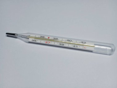 Beyaz arka planda izole edilmiş vücut ısısını ölçmek için cam cıva tıbbi termometre. Sıcaklık ölçeğinde cıva termometresi.