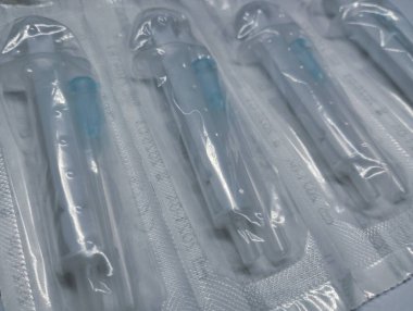 İğnelerle paketlenmiş plastik steril şırıngalar. Vücuda uyuşturucu verilmesi için gerekli eşyalar.