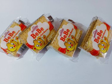 Plastik ambalajda küçük kuru kurabiyeler. Beyaz arka plana dağılmış kurabiyeler