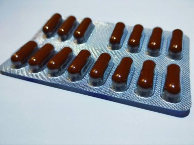 Kahverengi kapsüllerde vitamin bulunan bir tabağın üst görüntüsü. İlaç ve tıbbi malzemelerin teması.