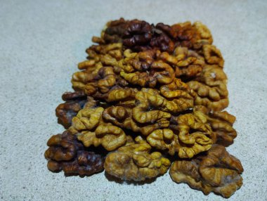 Gri arka planda ceviz çekirdekleri birikti. Yiyecek ve sağlıklı yiyecek ve malzeme teması.