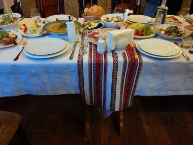 Lokantada servis yaptım. Yemekleri ve yemekleri bir restoranda nakışlı bir masa örtüsünün üzerinde..
