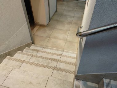 Bodruma inen bir odadaki beton merdivenler duvara vidalanmış seramik kiremitlerle doludur..