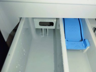 Çamaşır makinesinde deterjan ve çamaşır tozu için beyaz plastik çekmece..