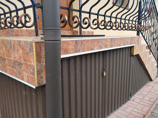 Лестницы с металлическими перилами во дворе. Лестница в дом с коваными железными перилами и запертой дверью.
