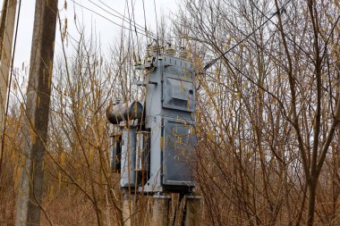 Küçük bir köyde enerji dağıtan eski metal trafolar. Enerji ve enerji aygıtları.