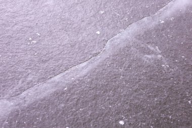 Yüzeyinde hava kabarcıkları ve dengesizlik olan çatlamış bir buz kütlesi. Buzun rengi gridir ve ilginç bir görsel etki yaratan çeşitli dokusal ayrıntılara sahiptir..