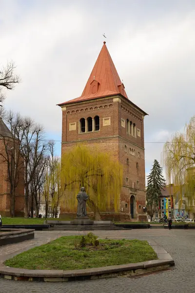 Drogobitch, Ukrayna, - 25 Mart 2025: Fotoğraf, kompozisyonun ortasında uzun bir tuğla kule ile şehrin tarihi mimarisini yakalar..